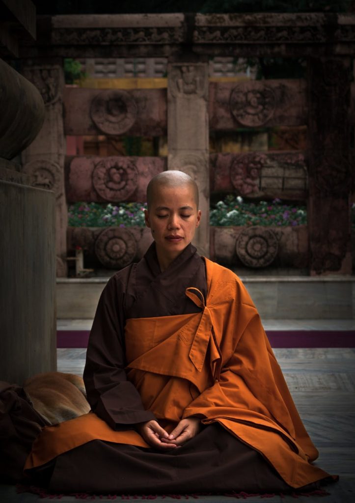 selective focus photography of monk during meditation